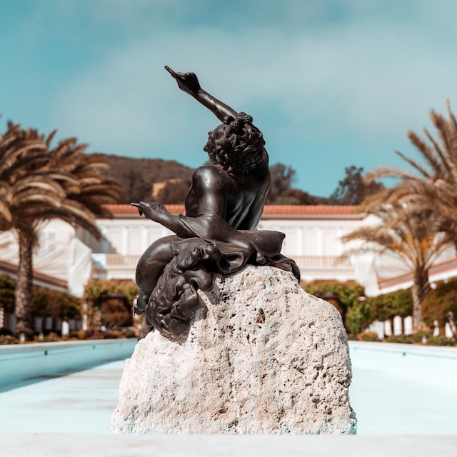 black statue of a man on a white rock at the Getty Villa in Malibu, California