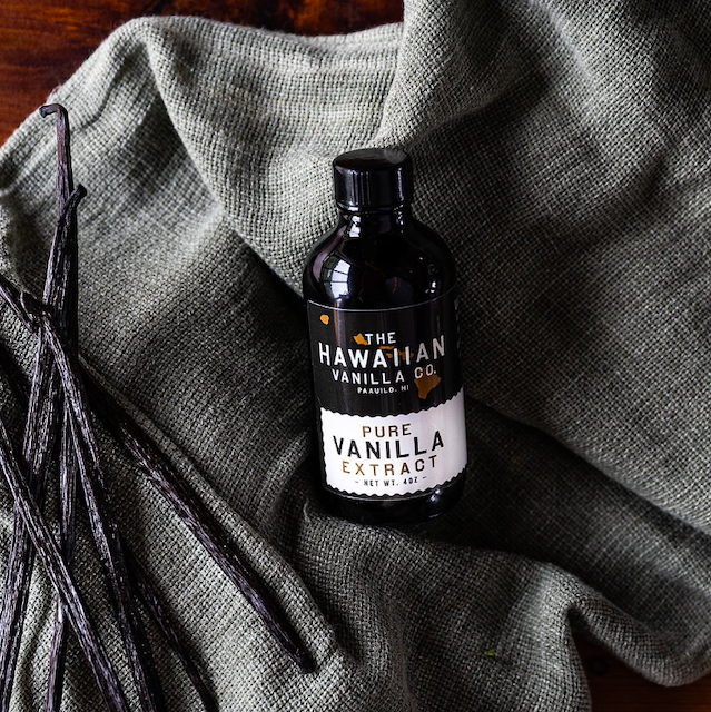 bottle of pure vanilla extract from The Hawaiian Vanilla Co. settled on a gray blanket next to a handful of vanilla beans. Taking a tour of the Hawaiian Vanilla Co. property is easily one of the coolest and most unusual things to do in Hilo, Hawaii.
