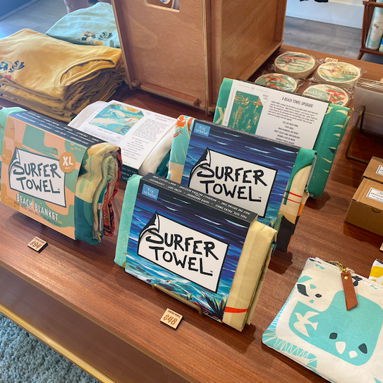 surf towels, tees, and coasters on display at Nick Kuchar Art and Design Co. gallery in Kailua. Kailua is such an artsy town that the art galleries should be at the top of every Kailua bucket list!