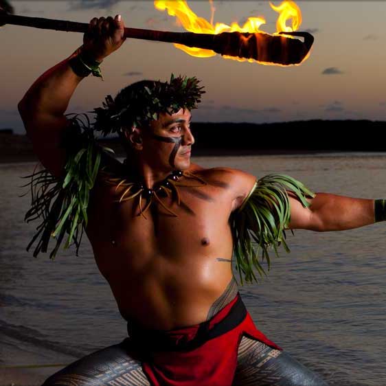 fire dancer in traditional dress in front of an ocean background. There are three luau in Ko Olina for you to choose from. It's one of the best things to do in Ko Olina if you're looking for a taste of authentic Hawaiian culture.