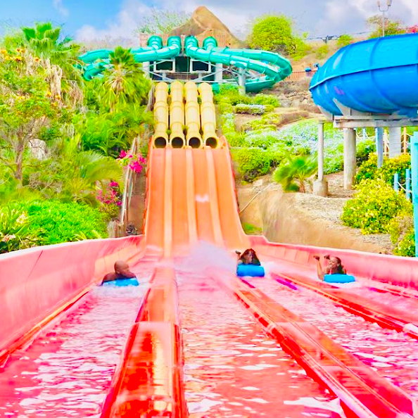 three people racing down rainbow-colored waterslides at Hawaii's only water park, Wet 'n' Wild Hawaii. It's just five minutes from Ko Olina, so it's one of the best things to do if you're hoping to switch things up.