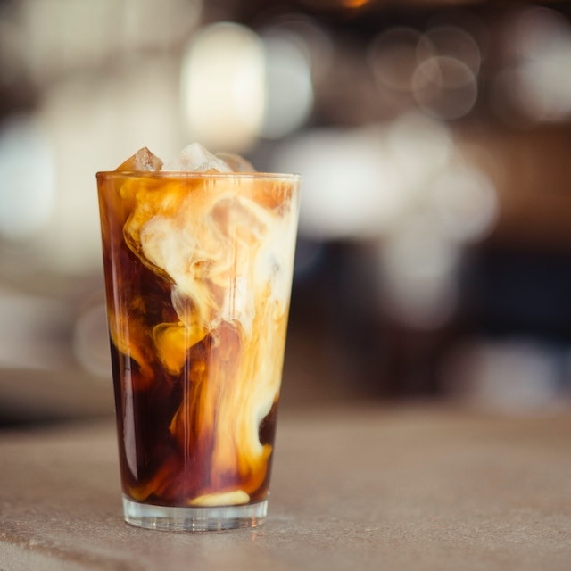 A cold brew coffee in a tall glass with the swirls of milk still diffusing into it. Coffee Works is the place to get a good ol' cup of joe on Lanai.